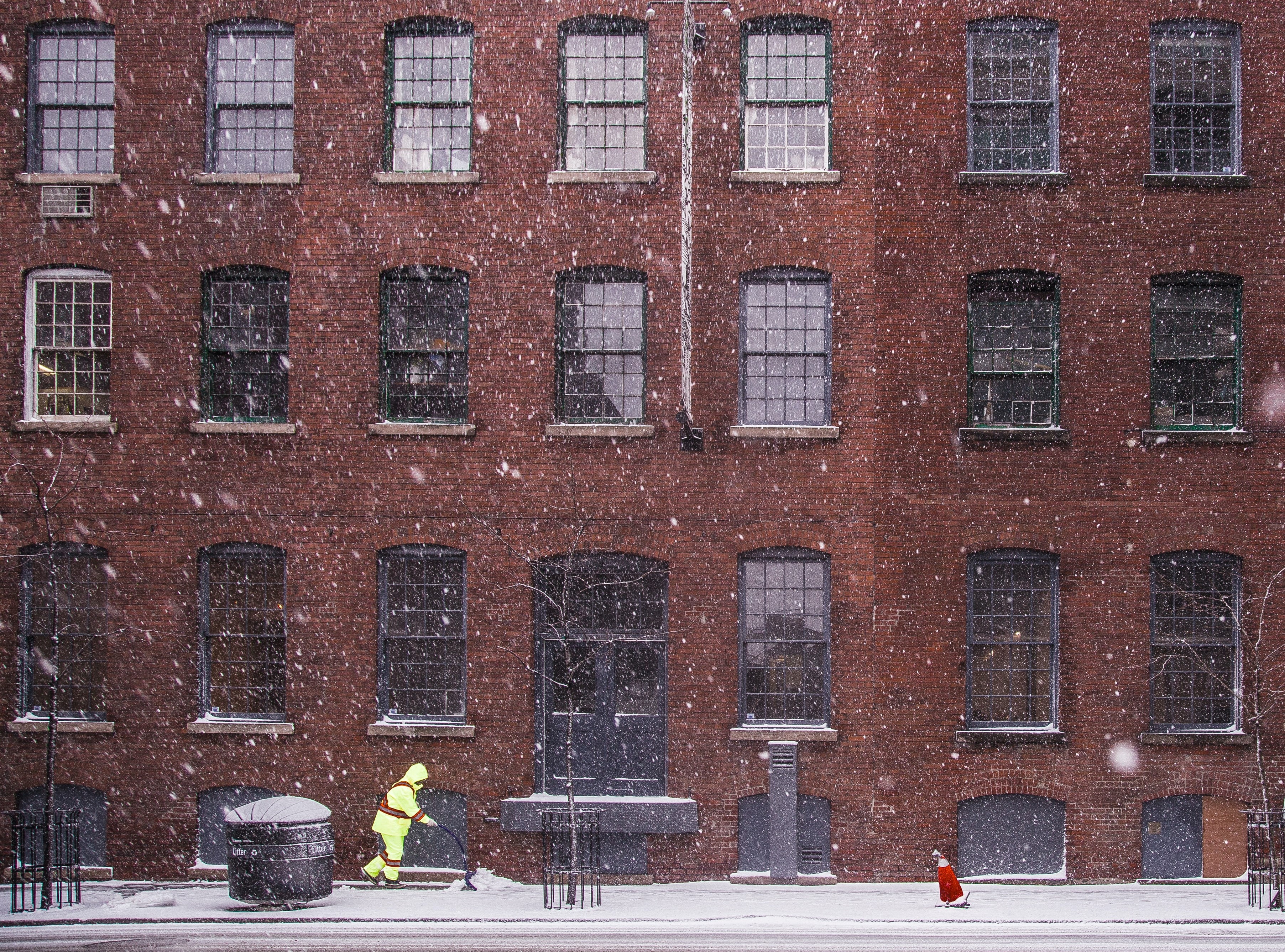 Person shovels snow on city street